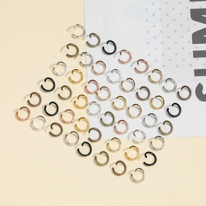 Vista macro di anellini aperti a C in finiture metalliche oro argento e bronzo