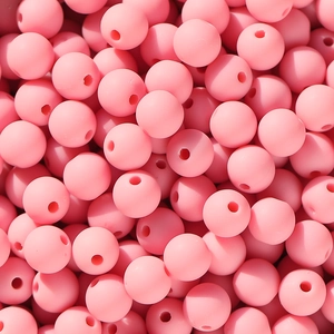 Makroaufnahme matter rosa Acryl-Perlen mit gefrosteter Textur und zentralen Löchern
