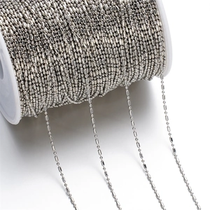 Macro shot of 1.5mm metal bead chain on a white spool for DIY jewelry making