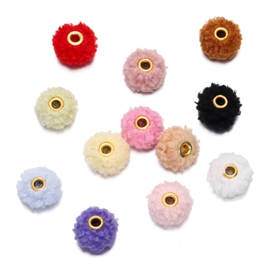 Macro detail of 18mm colorful teddy velvet beads with golden metal eyelets for DIY crafts