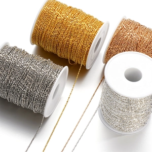 Macro shot of 1.5mm metal bead chains in four metallic colors on white spools for DIY jewelry