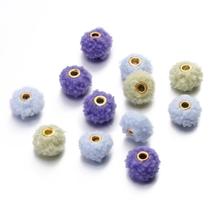 Close-up of 18mm soft teddy fleece beads with gold metal eyelets for DIY jewelry crafts