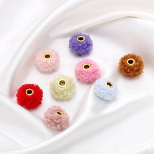 Close-up of 18mm teddy velvet beads with gold metal cores on white satin