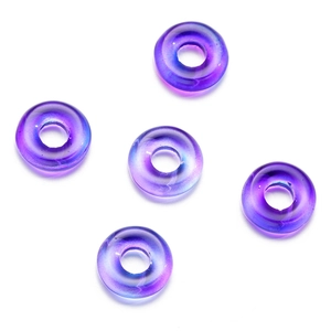 Makro-Detail von blau-violetten Glasperlen mit Farbverlauf und glänzendem Metall-Finish