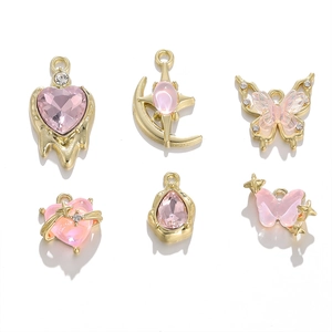Detailansicht von rosa Kristall- und Goldlegierungs-Anhängern in Herz- und Schmetterlingsform