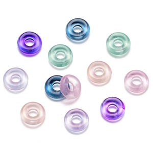 Detailansicht bunter, lichtdurchlässiger Glasperlen in Donutform für DIY-Schmuck