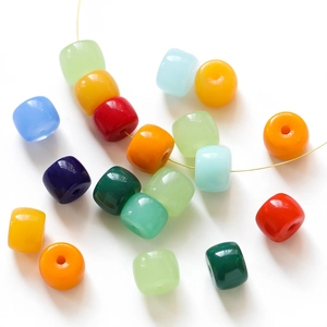 Close-up of colorful barrel-shaped glass beads on a wire for DIY jewelry making