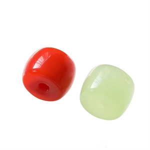 Close-up of cylindrical glass beads in red and green for DIY jewelry making