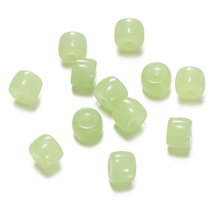 Macro detail of light green translucent cylinder glass beads with a smooth oil finish