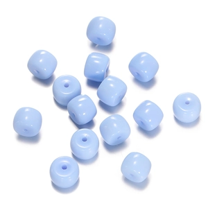 Close-up of light blue cylindrical glass beads with a matte finish for DIY jewelry making