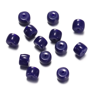 Macro shot of glossy dark blue cylinder glass beads with center holes for DIY jewelry