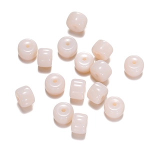 Macro view of light cream cylinder glass beads for DIY jewelry making and handmade crafts