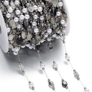 Macro detail of stainless steel DIY jewelry chain with pearls and natural stone beads