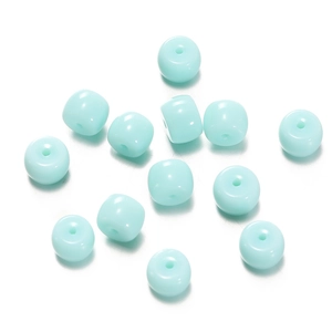 Macro shot of light blue flat round glass cylinder beads with smooth polished finish