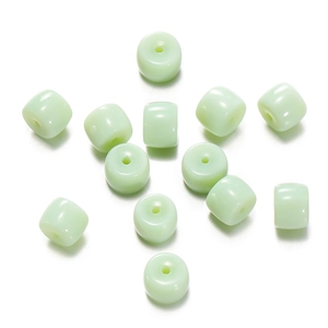 Detailed view of light green translucent cylinder glass beads with smooth polished finish