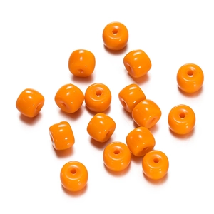 Macro detail of glossy orange cube-shaped beads for DIY jewelry and crafts