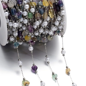 Detailed macro view of DIY colorful crushed stone and pearl stainless steel chain on a spool