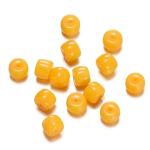 Macro view of bright yellow cylinder glass spacer beads for DIY jewelry making