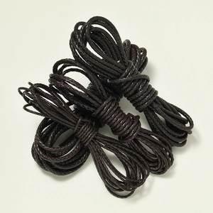 Detail of dark brown braided leather cord showing textured three-strand weave for DIY jewelry