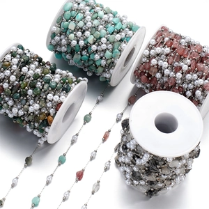 Detail of multi-color semi-precious stone and pearl bead chains on white plastic spools
