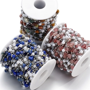 Macro shot of colorful natural stone chips and faux pearl beads on stainless steel chains
