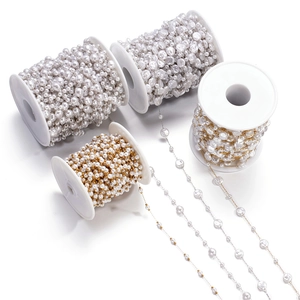Detail einer DIY-Schmuckkette mit runden und barocken Perlen auf Gold- und Silberspulen