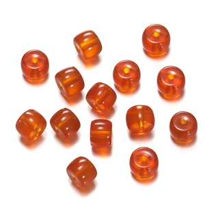 Detailed view of orange translucent glass cylinder beads for handmade DIY jewelry crafting