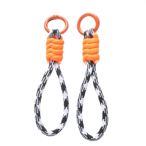 Détail de cordon tressé pour téléphone avec anneaux orange et cordes tressées noir et blanc