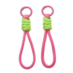 Détail d'une lanière tressée bicolore rose et vert fluo avec boucle en métal