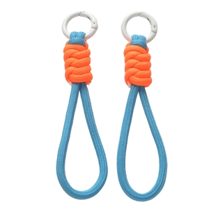 Détail de la dragonne tressée bleue et orange avec mousqueton blanc et texture