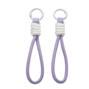 Détail des dragonnes tressées violettes et blanches avec des fermoirs ronds en métal