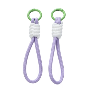 Détail de dragonnes tressées violettes et blanches avec mousquetons verts ronds