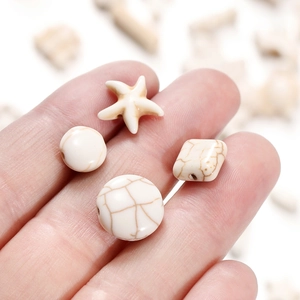 Macro shot of cream white synthetic turquoise beads in star and disk shapes for DIY jewelry