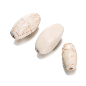 Detailed macro of oval white turquoise beads with brown marble patterns for jewelry DIY