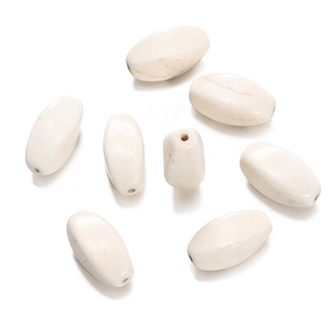 Macro detail of oval synthetic white turquoise beads with natural marble texture for DIY jewelry
