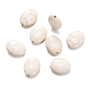 Macro view of oval white turquoise beads with natural brown veins for DIY jewelry making