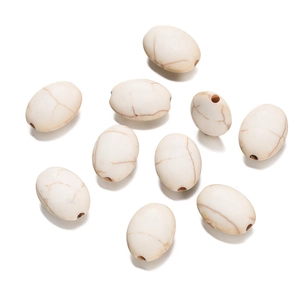 Detailed view of polished oval white turquoise beads with natural brown marble texture