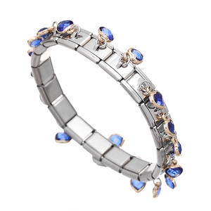 Detail of Italian charm bracelet links with blue crystal heart charms in gold settings