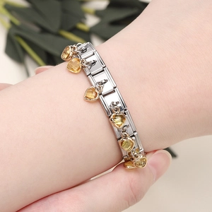 Wrist close-up of stainless steel modular bracelet with yellow heart crystal charms