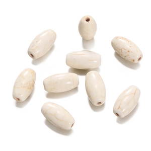 Detailed view of oval synthetic white turquoise beads with natural brown marble texture