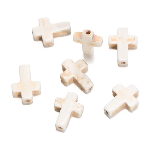Macro detail of white turquoise cross beads with marble texture for DIY jewelry making