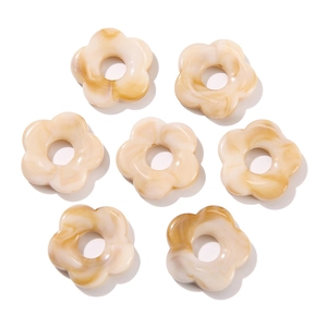 Detailed macro view of 26mm acrylic flower beads with cream amber marble texture
