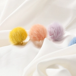 Macro detail of 17mm colorful faux mink fur pompoms with gold loops for DIY jewelry