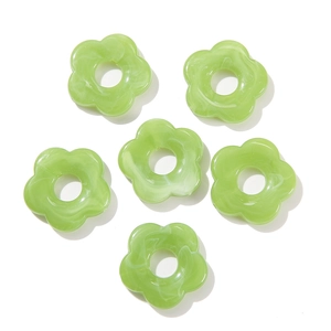 Macro detail of 26mm acrylic flower beads with green marble pattern for DIY jewelry