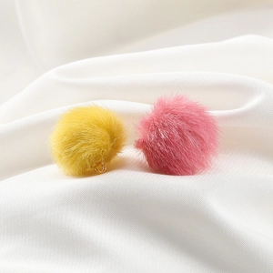 Macro shot of 17mm faux mink fur pompom charms with gold loops for DIY jewelry making