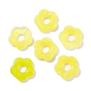 Macro detail of yellow gradient acrylic flower beads with smooth marble texture for DIY