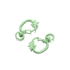 Dettaglio di moschettoni a forma di fragola verde menta con anelli metallici rotanti