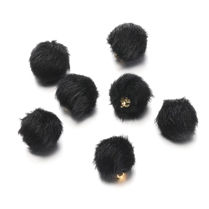 Close-up of black faux mink fur pom-poms with golden metal rings for DIY jewelry