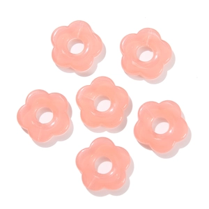 Detail view of 26mm pink acrylic flower beads with five petals and center hole for DIY