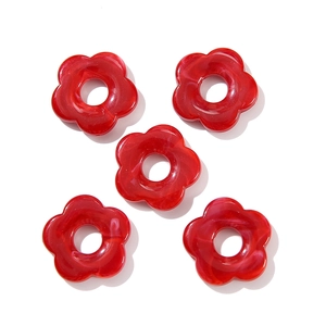 Macro detail of five-petal dark red acrylic flower beads with marble texture for DIY jewelry